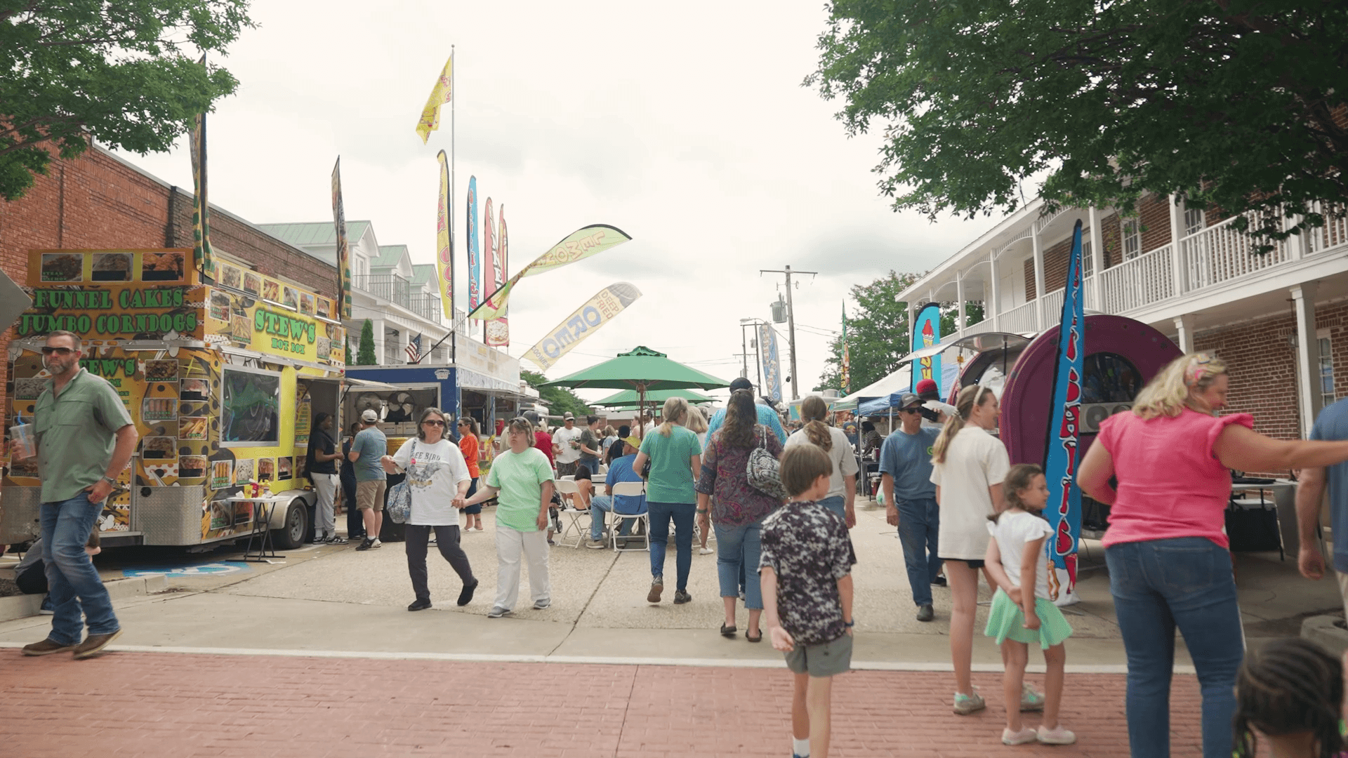 Street festival with food vendors, flags, and crowds in downtown DeSoto County